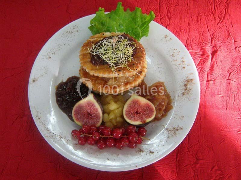 Assiette garnie de gaufres, figues fraîches, groseilles, confitures, pommes caramélisées et salade verte sur nappe rouge.