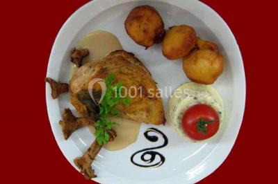 Pyramide de macarons colorés surmontée de figurines de mariés, présentée sur une table rouge en extérieur.