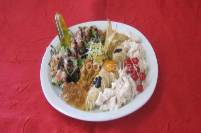 Pyramide de macarons colorés surmontée de figurines de mariés, présentée sur une table rouge en extérieur.