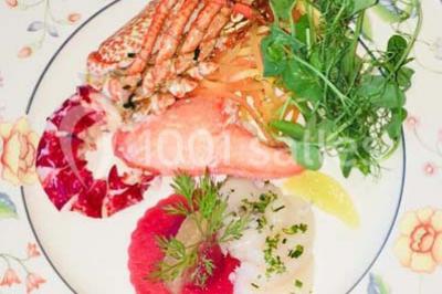 Plateau de bouchées variées comprenant verrines, toasts garnis, mini-sandwichs et décorations florales.