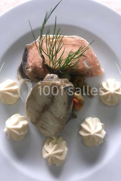 Assiette composée de morceaux de poisson cuits, accompagnés de quenelles de purée et décorée d'aneth.