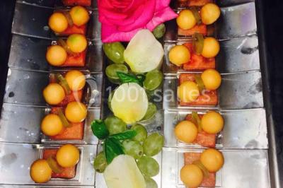 Plateau de bouchées variées comprenant verrines, toasts garnis, mini-sandwichs et décorations florales.