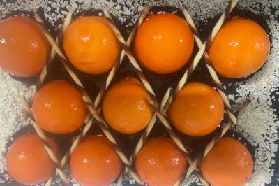 Assiette de saumon fumé tranché avec noix, graines et herbes, accompagnée de pain, fromage et citron sur une table.