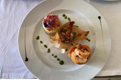 Plateau de crudités colorées avec radis, carottes, poivrons, chou-fleur et trempette au centre, présenté sur un lit de…