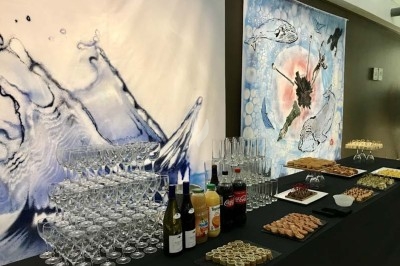 Table ronde élégamment dressée avec nappes blanches, couverts alignés, verres, serviettes roulées et décoration florale…