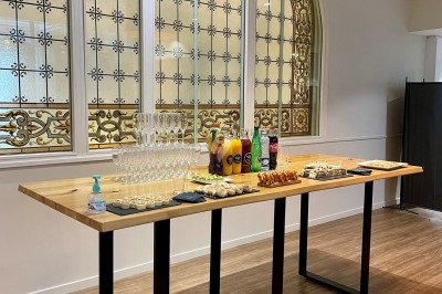 Table ronde élégamment dressée avec nappes blanches, couverts alignés, verres, serviettes roulées et décoration florale…