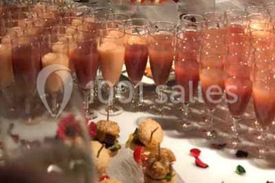 Plat de viande grillée avec sauce et légumes dans une cocotte, présenté sur une planche en bois.