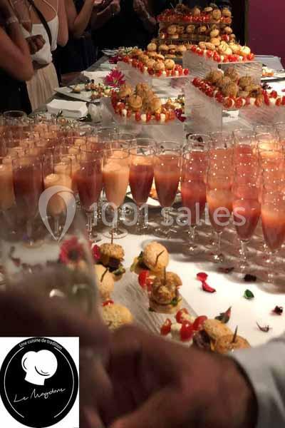 Buffet avec verrines, coupes de cocktail et assortiments de petits fours sur une table décorée.