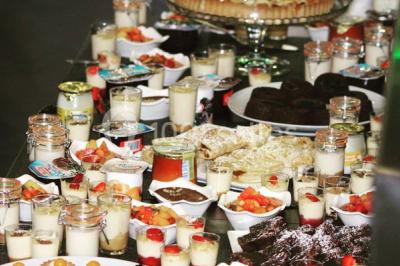 Plat de viande grillée avec sauce et légumes dans une cocotte, présenté sur une planche en bois.