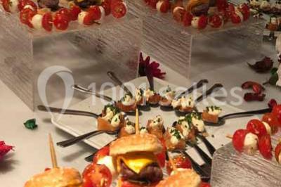 Plat de viande grillée avec sauce et légumes dans une cocotte, présenté sur une planche en bois.