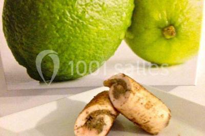 Plat de viande grillée avec sauce et légumes dans une cocotte, présenté sur une planche en bois.