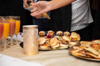 Plat de viande grillée avec sauce et légumes dans une cocotte, présenté sur une planche en bois.