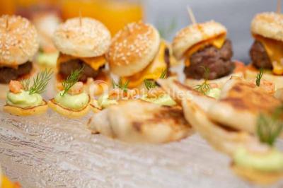 Plat de viande grillée avec sauce et légumes dans une cocotte, présenté sur une planche en bois.