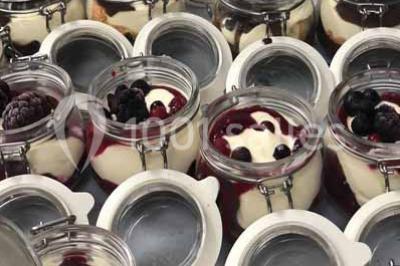 Plat de viande grillée avec sauce et légumes dans une cocotte, présenté sur une planche en bois.