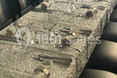 Plat de viande grillée avec sauce et légumes dans une cocotte, présenté sur une planche en bois.