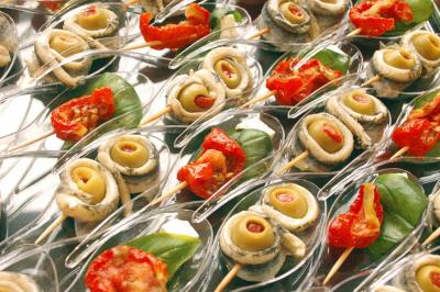 Plateau de bouchées variées comprenant mini-sandwichs, macarons, brochettes, verrines et roulés aux légumes.