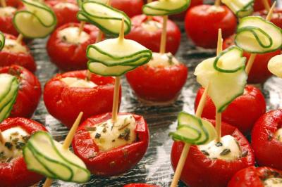 Plateau de bouchées variées comprenant mini-sandwichs, macarons, brochettes, verrines et roulés aux légumes.