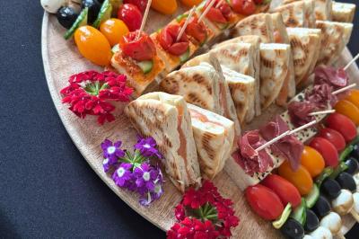 Plateau de bouchées variées comprenant mini-sandwichs, macarons, brochettes, verrines et roulés aux légumes.