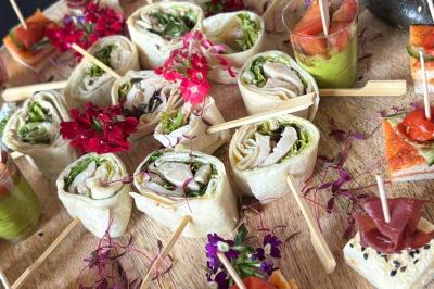 Plateau de bouchées variées comprenant mini-sandwichs, macarons, brochettes, verrines et roulés aux légumes.