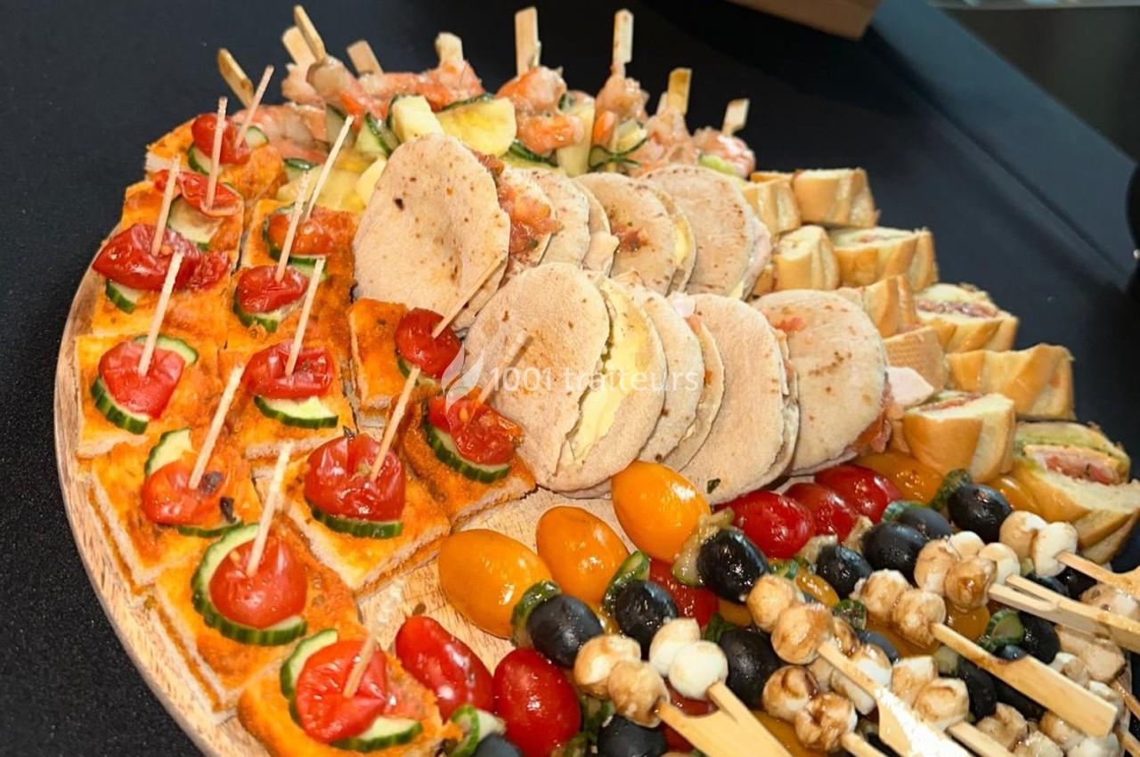 Plateau de bouchées apéritives variées avec brochettes de légumes, mini-sandwichs et tartines garnies.