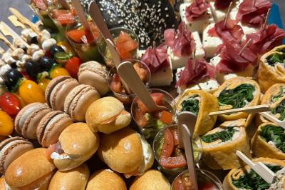 Plateau de bouchées variées comprenant mini-sandwichs, macarons, brochettes, verrines et roulés aux légumes.