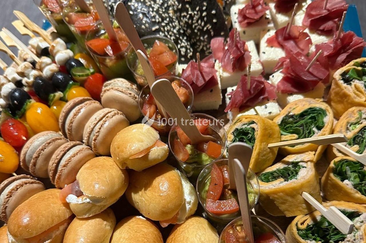 Plateau de bouchées variées comprenant mini-sandwichs, macarons, brochettes, verrines et roulés aux légumes.