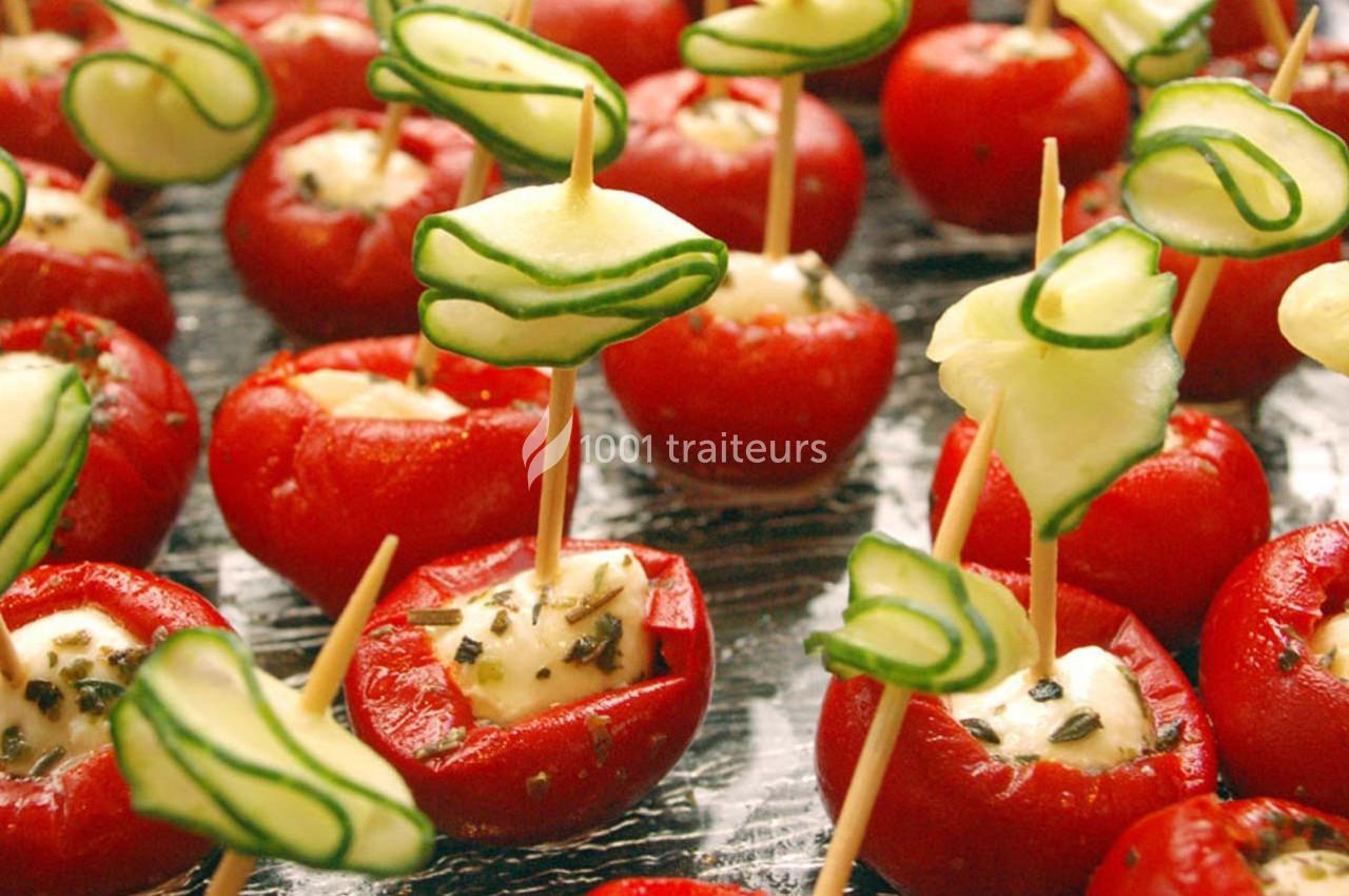 Tomates cerises farcies au fromage frais, décorées de tranches de concombre sur des piques en bois.