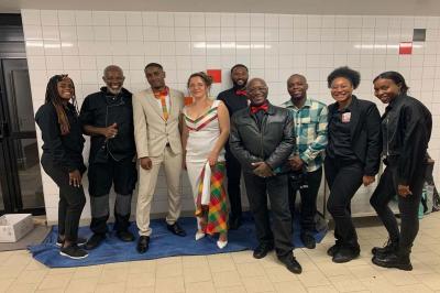 Assiette garnie de brochettes sur un ananas, accompagnée de légumes, sauces et bouchées frites.