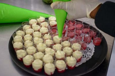 Assiette garnie de brochettes sur un ananas, accompagnée de légumes, sauces et bouchées frites.