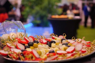Assiette garnie de brochettes sur un ananas, accompagnée de légumes, sauces et bouchées frites.