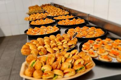 Assiette garnie de brochettes sur un ananas, accompagnée de légumes, sauces et bouchées frites.