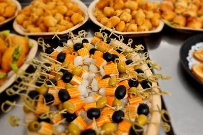 Assiette garnie de brochettes sur un ananas, accompagnée de légumes, sauces et bouchées frites.