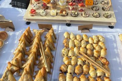 Assiette garnie de brochettes sur un ananas, accompagnée de légumes, sauces et bouchées frites.