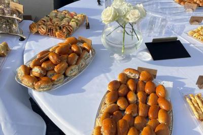 Assiette garnie de brochettes sur un ananas, accompagnée de légumes, sauces et bouchées frites.