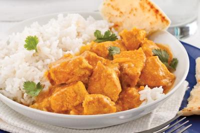 Assiette garnie de brochettes sur un ananas, accompagnée de légumes, sauces et bouchées frites.