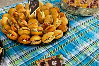 Assiette garnie de brochettes sur un ananas, accompagnée de légumes, sauces et bouchées frites.