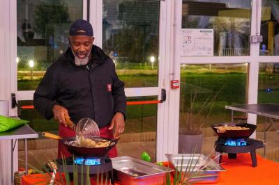 Assiette garnie de brochettes sur un ananas, accompagnée de légumes, sauces et bouchées frites.