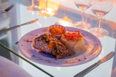 Assiette garnie de brochettes sur un ananas, accompagnée de légumes, sauces et bouchées frites.