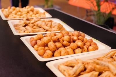 Assiette garnie de brochettes sur un ananas, accompagnée de légumes, sauces et bouchées frites.