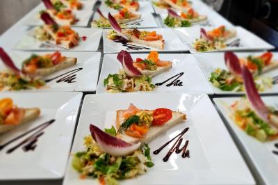 Assiette garnie de brochettes sur un ananas, accompagnée de légumes, sauces et bouchées frites.