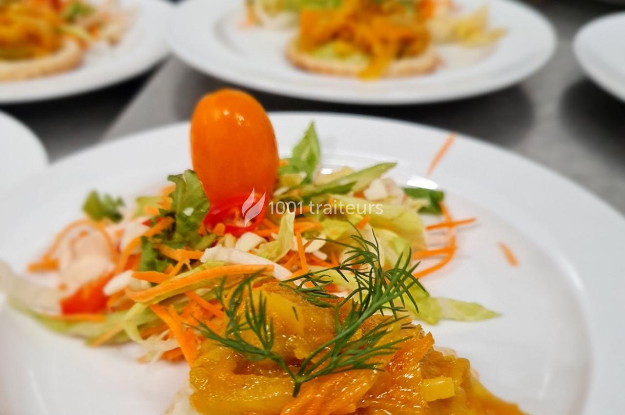 Assiette garnie de crudités colorées et d'une préparation aux légumes sur une base de pain, décorée d'herbes fraîches.