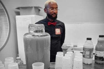 Assiette garnie de brochettes sur un ananas, accompagnée de légumes, sauces et bouchées frites.