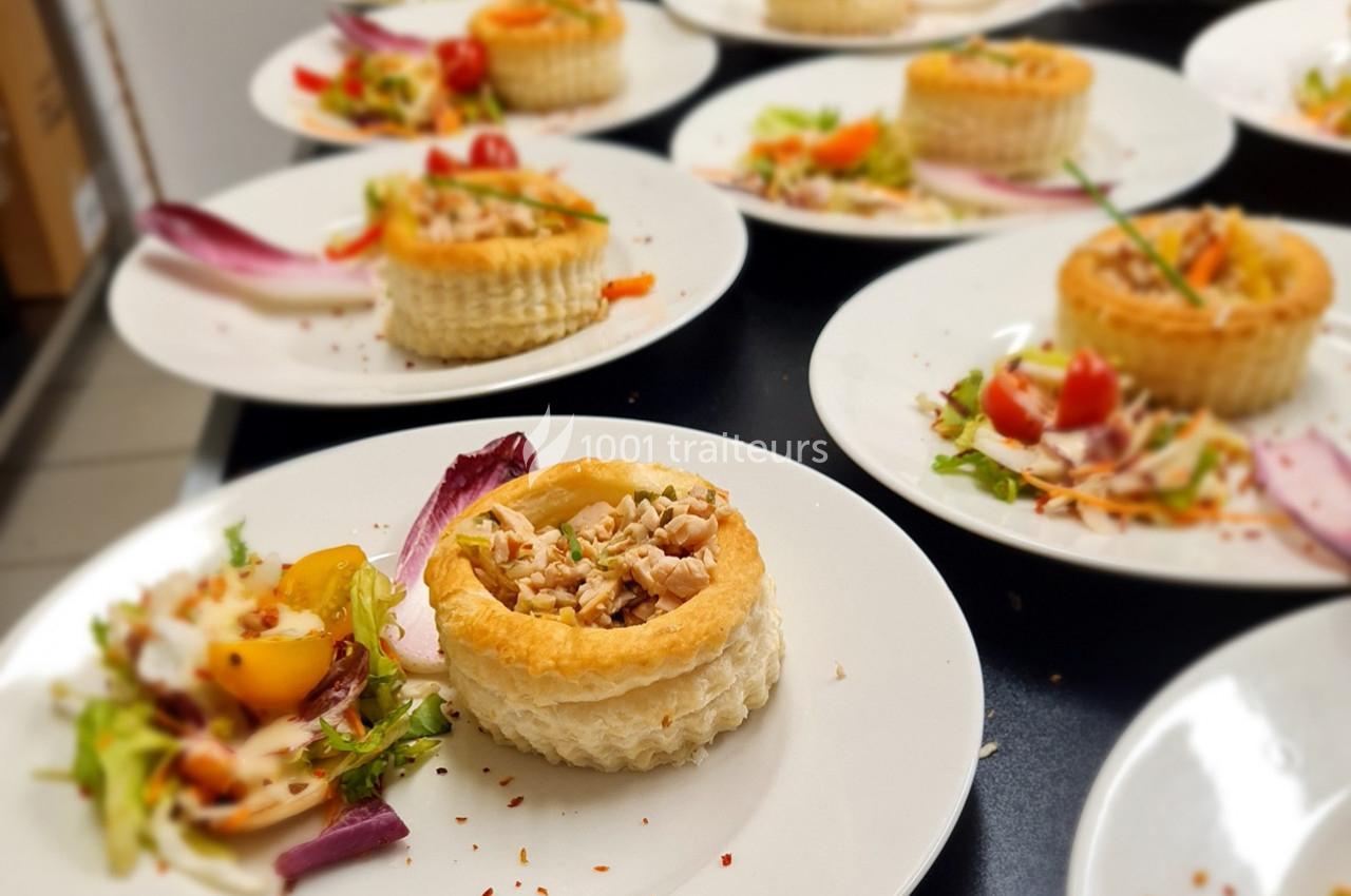 Assiette contenant un vol-au-vent garni de poulet et accompagné d'une salade colorée avec des légumes frais.