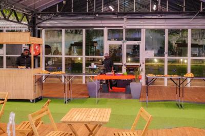 Assiette garnie de brochettes sur un ananas, accompagnée de légumes, sauces et bouchées frites.