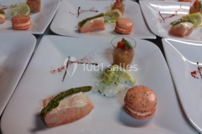 Table de buffet dressée en extérieur avec boissons, verrines, desserts et une pièce montée sur une nappe noire.