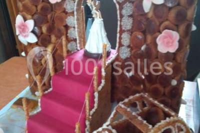 Table de buffet dressée en extérieur avec boissons, verrines, desserts et une pièce montée sur une nappe noire.