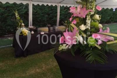 Table de buffet dressée en extérieur avec boissons, verrines, desserts et une pièce montée sur une nappe noire.