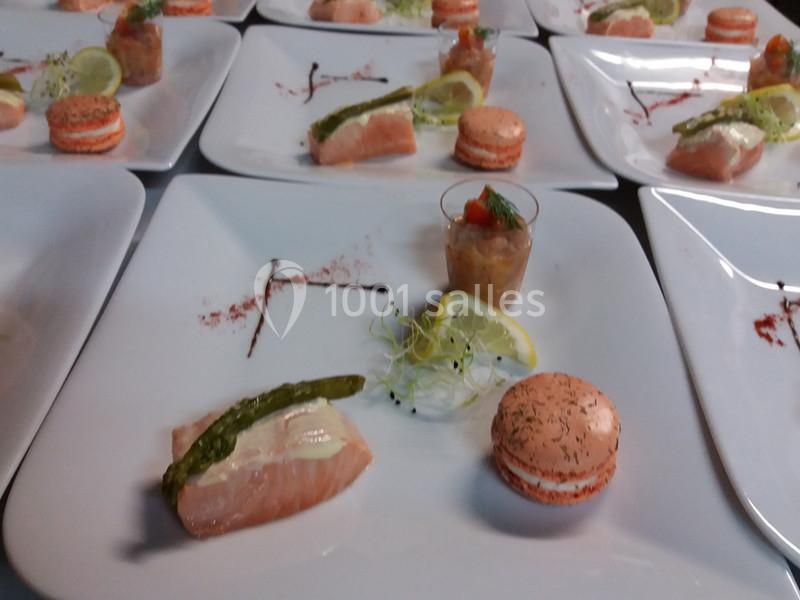 Assiettes dressées avec saumon, macaron salé, verrine et décorations de citron, asperge et pousses vertes.