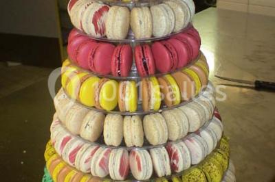Table de buffet dressée en extérieur avec boissons, verrines, desserts et une pièce montée sur une nappe noire.