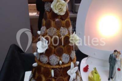 Table de buffet dressée en extérieur avec boissons, verrines, desserts et une pièce montée sur une nappe noire.